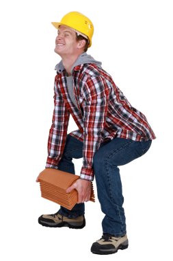 Tradesman lifting a heavy load clipart