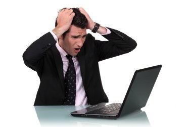 A businessman pissed at his laptop. clipart