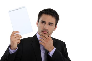 Businessman holding up a blank notepad clipart