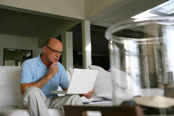Łysy mężczyzna za pomocą swojego laptopa w domu — Zdjęcie stockowe