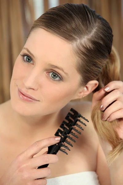 Genç ve güzel kadın saçlarını untangling — Stok fotoğraf