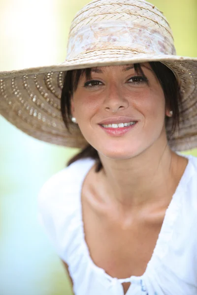 Bruna di 30 anni con un cappello di paglia e un vestito estivo — Foto Stock