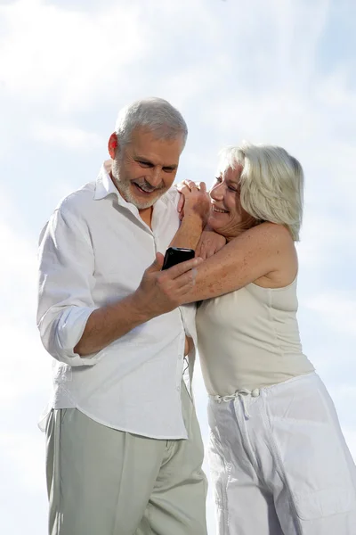 Старшая пара в отпуске фотографируется с мобильным телефоном — стоковое фото