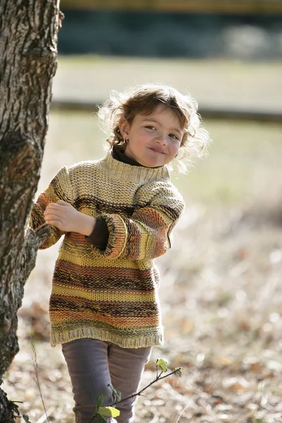 Chica joven jugando entre los árboles — Foto de Stock