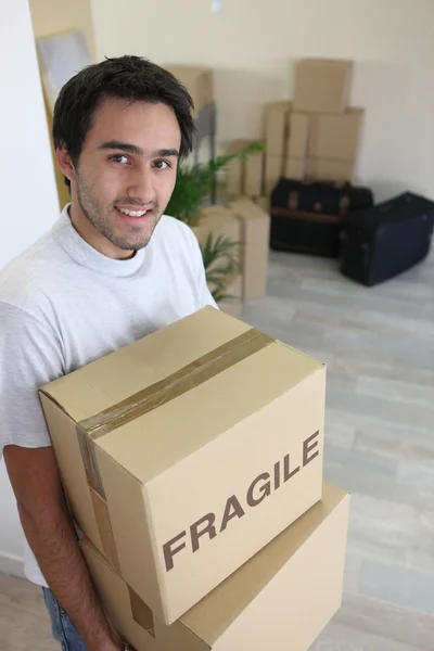 Young man moving boxes marked f — Stock Photo, Image