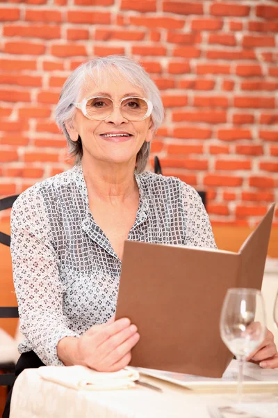 Frau liest im Restaurant ein Menü — Stockfoto