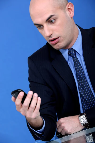 Чоловік тримає телефон з виразом несподіванки — стокове фото