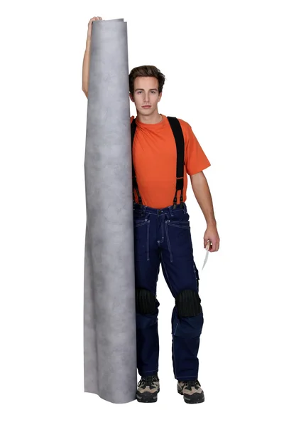 Tradesman holding a roll of linoleum flooring — Zdjęcie stockowe
