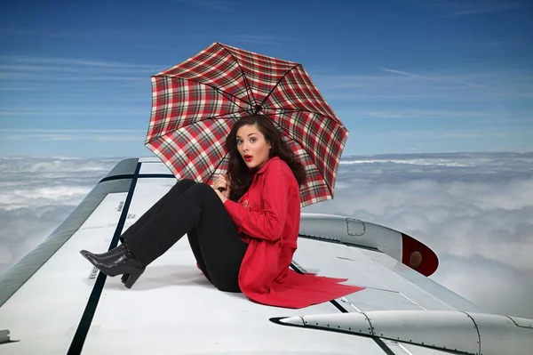 Morena sentada en el ala de un avión — Foto de Stock