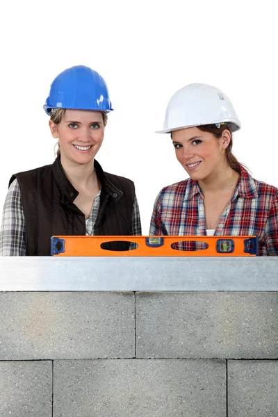 Two craftswomen measuring a wall with a level — Stock Photo, Image
