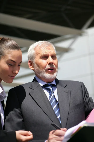 Hombre de negocios principal hablando con una mujer joven — Foto de Stock