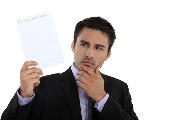 Empresário segurando um bloco de notas em branco — Fotografia de Stock