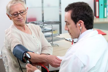 Older woman having her blood pressure taken clipart