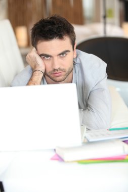 Bored man using laptop clipart