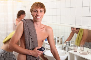 Young man in a shared bathroom clipart