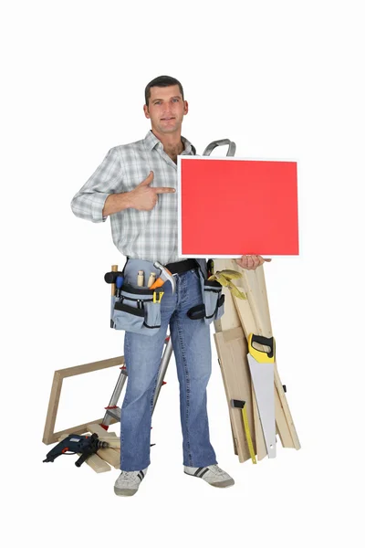 Carpinteiro segurando painel vermelho — Fotografia de Stock