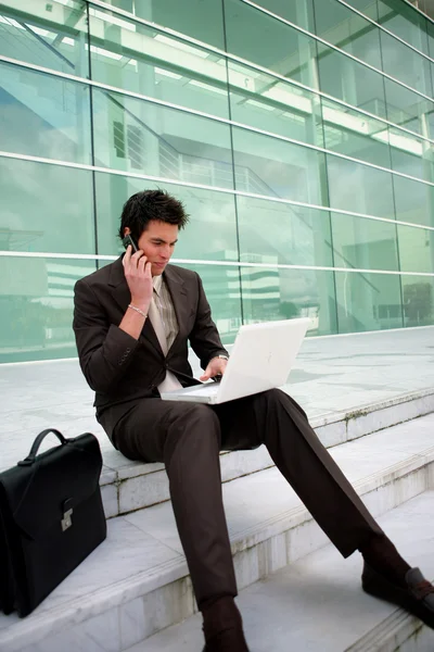 Businessman sat on steps working — Stock Photo, Image