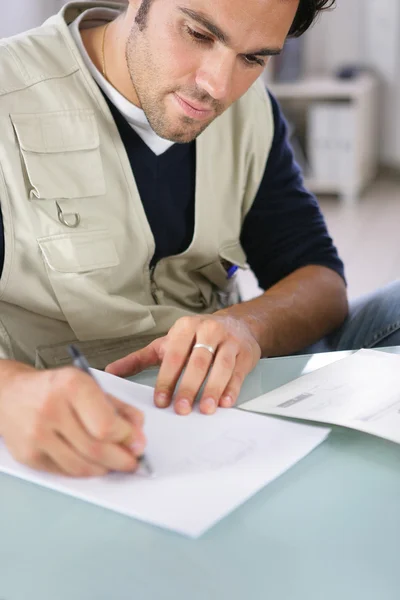 Człowiek piszący na kartce papieru — Zdjęcie stockowe