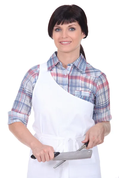 Female chef stood with knife and sharpener — Stock Photo, Image