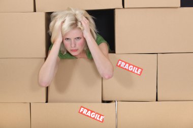 Stressed woman surrounded by boxes clipart