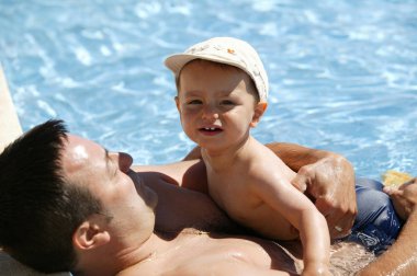 Man enjoying a swim with his son clipart