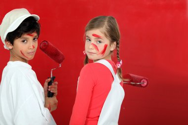 Kids painting a wall in red clipart