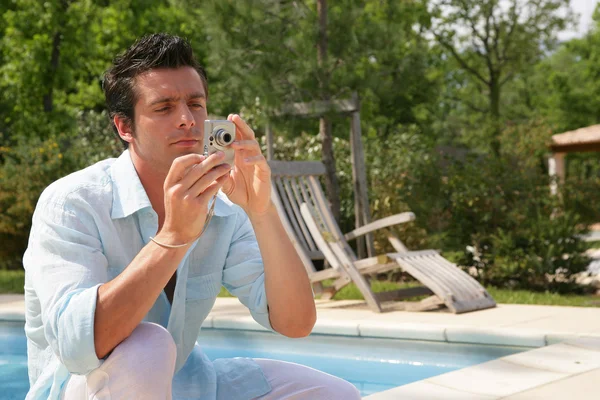 Un homme prend une photo près d'une piscine — Photo