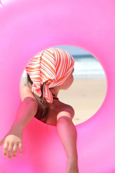 Kauçuk halka tutarak sahilde küçük kız — Stok fotoğraf