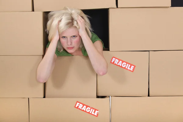 Stressed woman surrounded by boxes — Stock Photo, Image