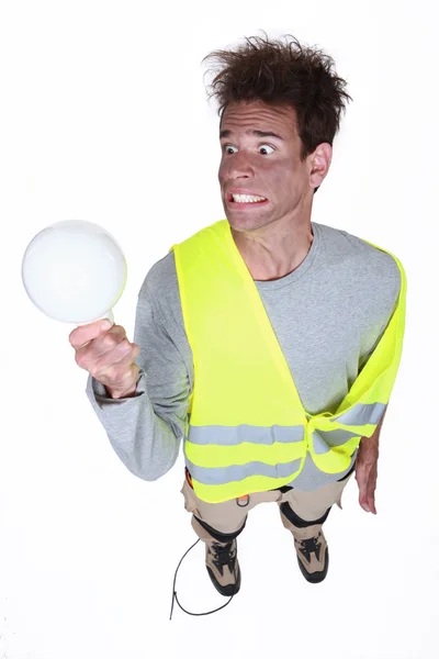 Legrační elektrikář drží náhradní žárovka — Stock fotografie