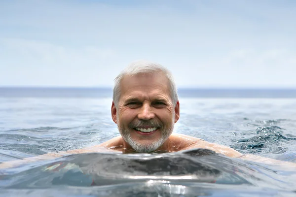 Пожилой человек плавает — стоковое фото