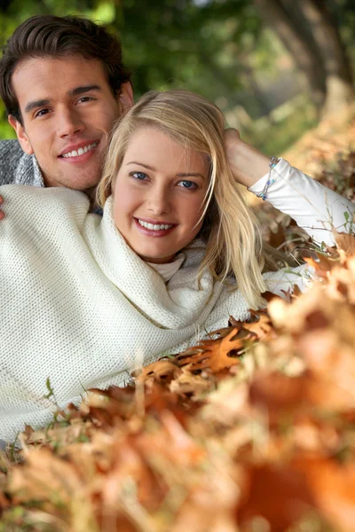 Retrato de una pareja sobre hojas — Foto de Stock