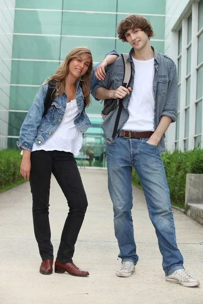 Cam fronted binanın önünde duran iki öğrenci — Stok fotoğraf