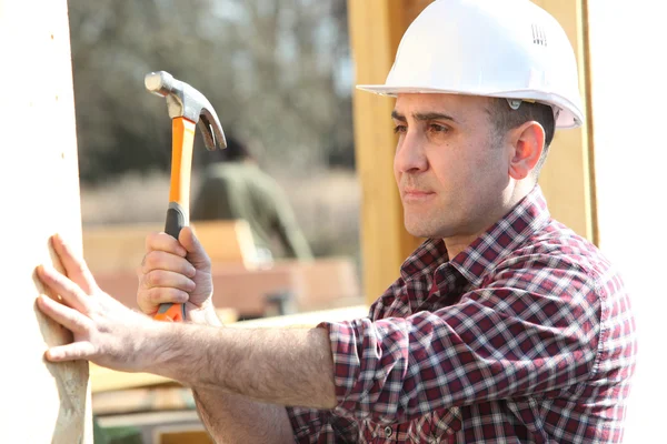 Handyman hitting a nail with a hammer — Stock Photo, Image