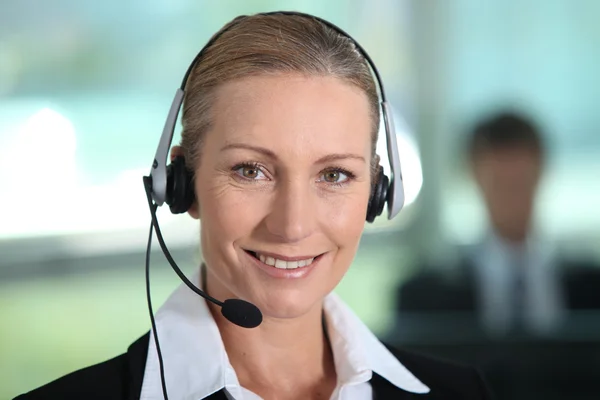 Frau lächelt mit Headset — Stockfoto