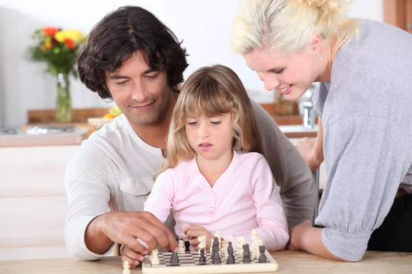 Молодая семья играет в шахматы — стоковое фото
