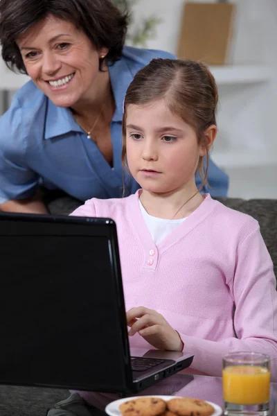 Κοριτσάκι, χρησιμοποιώντας φορητό υπολογιστή στο σπίτι — Φωτογραφία Αρχείου