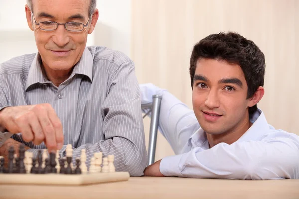 Otec a syn hrají šachy — Stock fotografie