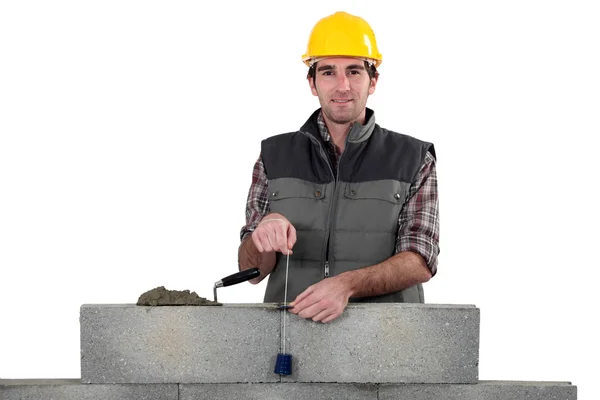 Bricklayer with a plumb line — Stock Photo, Image