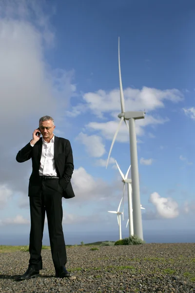 Homem no telefone na frente de turbinas eólicas — Fotografia de Stock