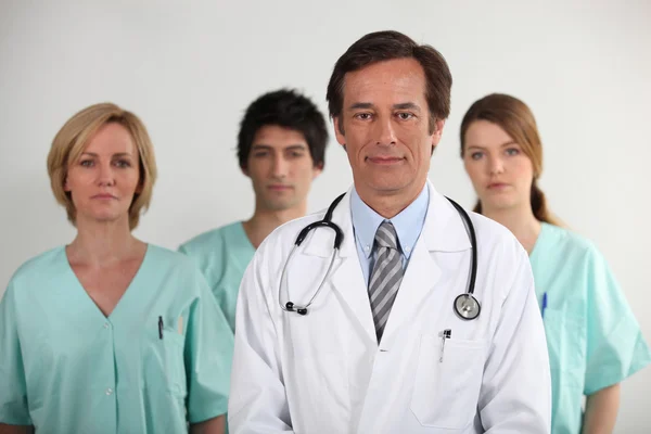 Мужчина-врач и его команда медсестер — стоковое фото
