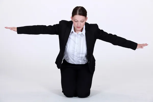 Knästående affärskvinna med armar som sträcks — Stockfoto