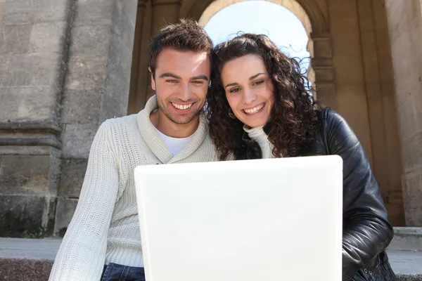 Couple assis avec un ordinateur portable — Photo