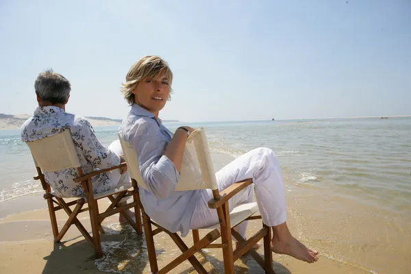 Ζευγάρι, κάθονται σε καρέκλες στην άκρη της παραλίας — Φωτογραφία Αρχείου
