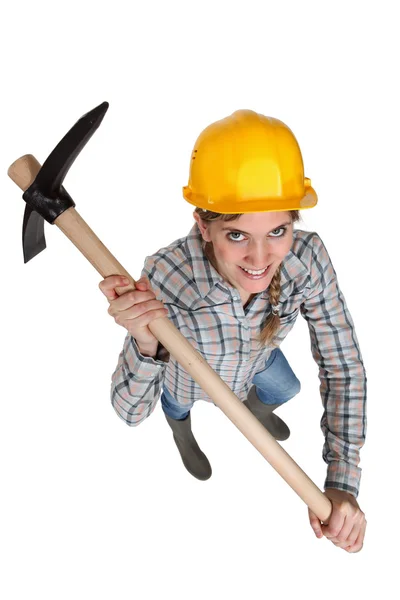 Woman with a helmet holding a pickaxe — Stock Photo, Image