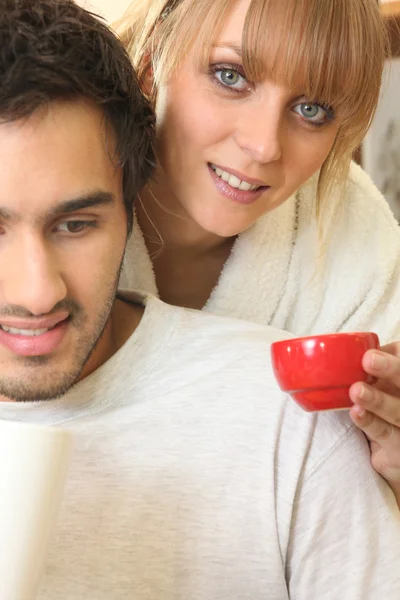 Jonge man zittend en jonge vrouw met kopje thee — Stockfoto