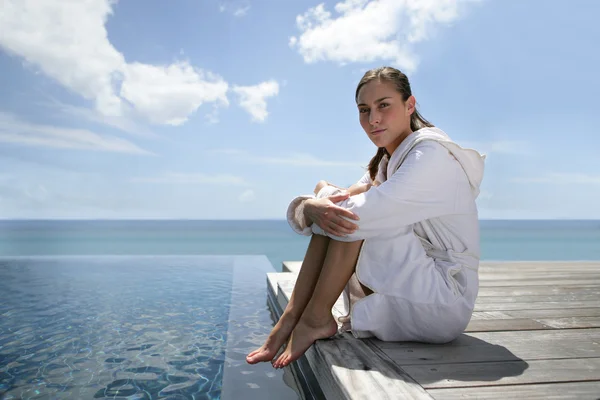 Brunette sat at theend of a jetty — Stock Photo, Image