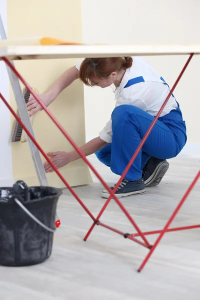 Mulher colocando acima papel de parede — Fotografia de Stock