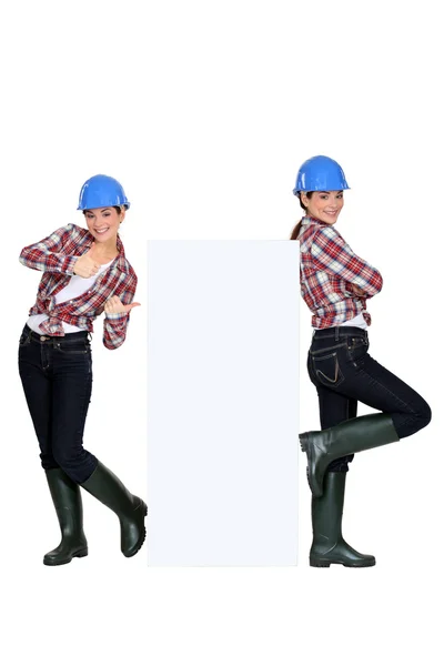 Twins standing around a blank sign — Stock Photo, Image