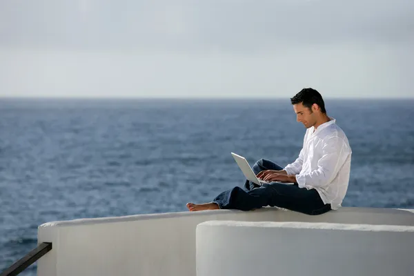 Άνθρωπος με υπολογιστή μπροστά στη θάλασσα — Φωτογραφία Αρχείου